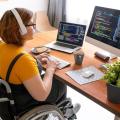 Ung kvinne i rullestol foran dataskjerm
