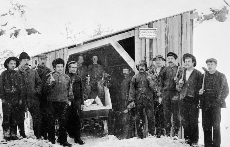 Et dusin gruvearbeidere foran gruveinngang
