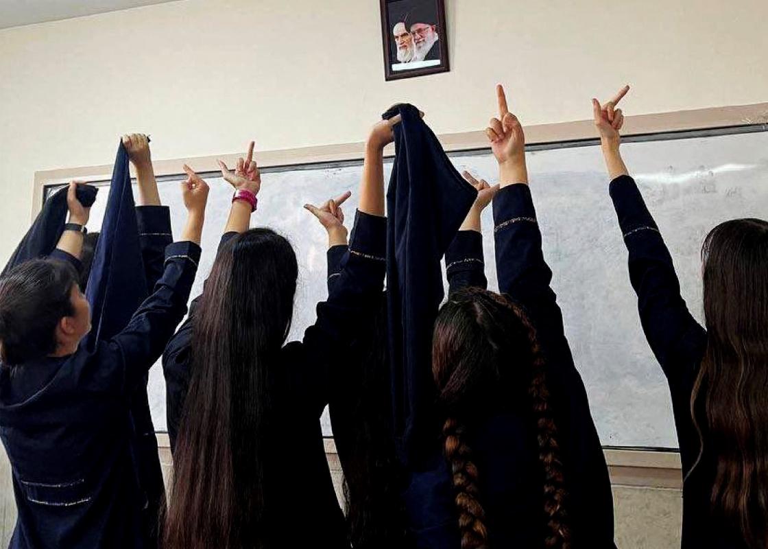 Iranske kvinner viser fingeren til et bilde av Khomeini
