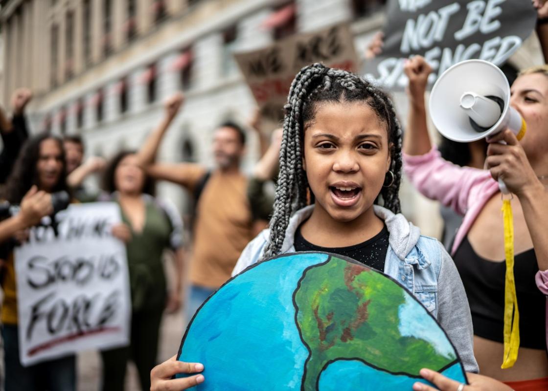 Jente holder bilde av jordkloden i klimademonstrasjon