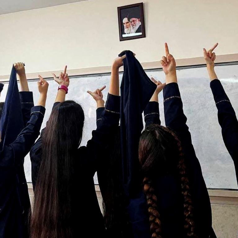 Iranske kvinner viser fingeren til et bilde av Khomeini