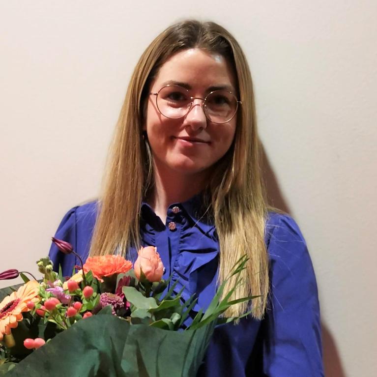 Foto: Anna Young/STK, UiO Ung kvinne med blomster i armene